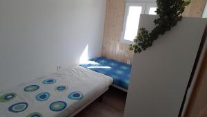 um pequeno quarto com uma cama e uma janela em Acogedor apartamento en el barrio del Parlamento de Andalucía (Sevilla) em Sevilha