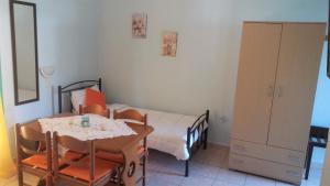 a small bedroom with a bed and a table and chairs at Mouragio Apartments in Tiros