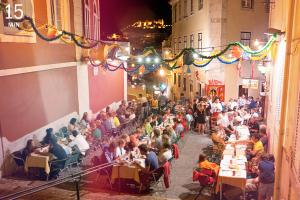 una folla di persone sedute ai tavoli in una strada di 18th Century Loft a Lisbona
