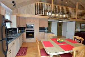 een keuken met een tafel met daarop een schaal fruit bij Paradis du Lac Nairne in Notre-Dame-des-Monts