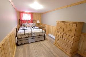 een slaapkamer met een bed en een ladekast bij Paradis du Lac Nairne in Notre-Dame-des-Monts