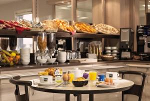 - une table avec des aliments et des boissons pour le petit-déjeuner dans l'établissement Ace Hotel Chateauroux Déols, à Déols