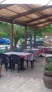 un grupo de mesas y sillas bajo un pabellón en La Campagnola Trattoria con Alloggio en Misano Adriatico