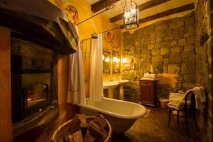 a stone bathroom with a tub and a sink at Hacienda San Agustin de Callo in Lasso +94 photos