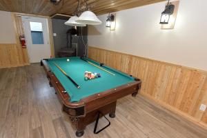 een pooltafel in een woonkamer met een zwembad bij Paradis du Lac Nairne in Notre-Dame-des-Monts +9 foto's