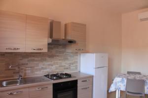 a kitchen with a white refrigerator and a sink at Residenza Santoro in Melendugno