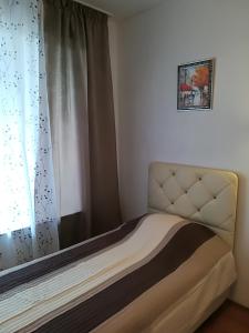een slaapkamer met een bed en een raam met een gordijn bij Cocoa Apartment in Varna