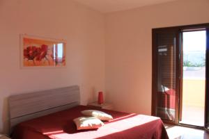 メレンドゥーニョにあるResidenza Santoroのベッドルーム1室(赤いシーツ付きのベッド1台、窓付)