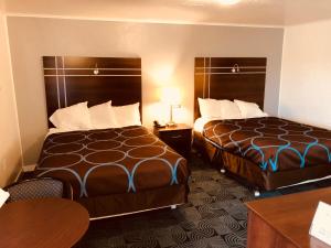 ein Hotelzimmer mit 2 Betten und einem Tisch in der Unterkunft Berkshire Inn in Pittsfield