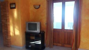 un televisor sentado en un puesto junto a una puerta en Appartamento Tuttavista, en Cala Gonone