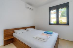sypialnia z białym łóżkiem i ręcznikami w obiekcie N Apartments w Sutomore