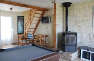 a living room with a pool table and a wood stove at Le Prat - Santec in Santec