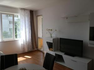 een woonkamer met een flatscreen-tv en een tafel bij Cocoa Apartment in Varna