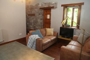 a living room with a couch and a television at Ty Carreg Fach Staycation Cottage Cardiff in Cardiff