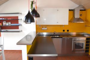 卡斯拉諾的住宿－Mansarda Caslano，厨房配有水槽和炉灶