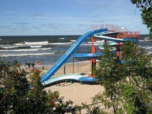 a blue slide on the beach near the ocean at Apartament Baltic Park Stegna in Stegna