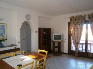 a living room with a dining room table and a television at Le Canne Apt 1 in San Teodoro