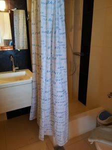 a shower curtain in a bathroom with a sink and a tub at Scorpina Villas in Agios Nikitas