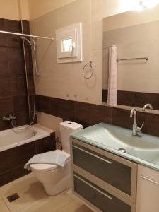 a bathroom with a toilet and a sink and a tub at Scorpina Villas in Agios Nikitas