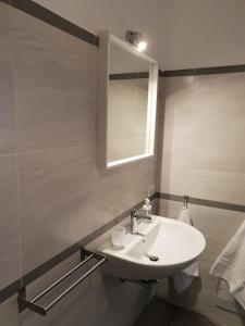 a white bathroom with a sink and a mirror at Riposto Etna Taormina Mare in Riposto