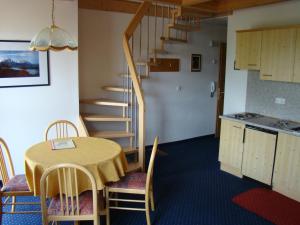 a dining room with a table and a spiral staircase at Pension Villa Claudia Augusta in Resia