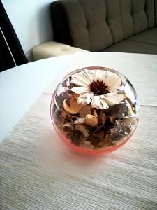 een glazen kom met een bloem erin op een tafel bij Cocoa Apartment in Varna