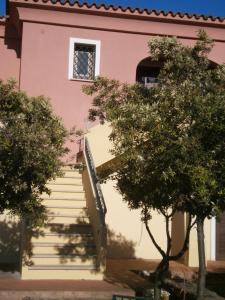 a staircase leading to a pink building with a window at Le Canne Apt 1 in San Teodoro