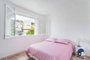 - une chambre blanche avec un lit rose et une fenêtre dans l'établissement Cosy flat just by the sea - Dodo et Tartine, au Pradet