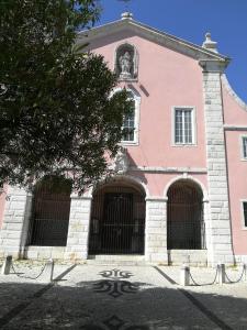 リスボンにあるFreeLisbonStudioの正面に門が二つあるピンクの建物