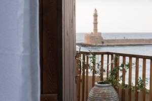 a vase on a balcony with a lighthouse in the background at Captain Vasilis Hotel in Chania Town
