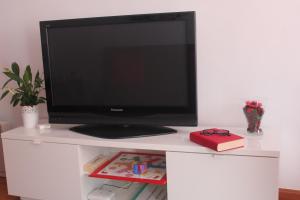 einen Fernseher auf einem weißen Schreibtisch mit einem Buch in der Unterkunft Casa Gonzalez in Posada