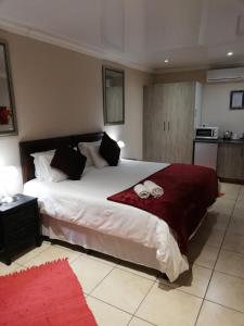 a bedroom with a large bed with two towels on it at Giardino a 194 in Welkom