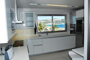 a kitchen with a sink and a window with a view at Super Luxury Penthouse in Jávea