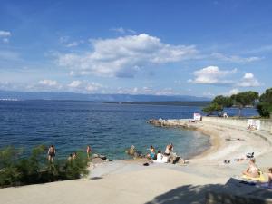 a group of people on a beach near the water at Apartment Grozic in Porat