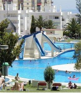 una gran piscina con un tobogán en un complejo en Estudio J-60, terraza & 1º planta en Benalmádena