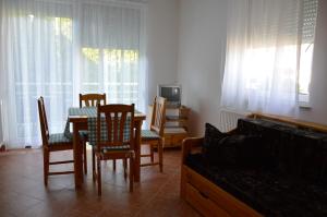 ein Wohnzimmer mit einem Tisch, Stühlen und einem Sofa in der Unterkunft Eman Apartmanház in Bük