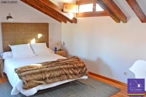 Un dormitorio con una cama con una manta. en La Casona de Castilnovo - Gay Men Only, en Valdesaz