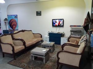 a living room with two couches and a tv at Nicea Hotel in Selcuk