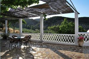 eine Terrasse mit einem Tisch und Stühlen sowie einem weißen Zaun in der Unterkunft Casa de Aulabar in Aulabar