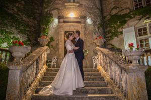 una sposa e uno sposo in piedi sulle scale al loro matrimonio di Hôtel & SPA Château de La Côte - Brantôme a Biras