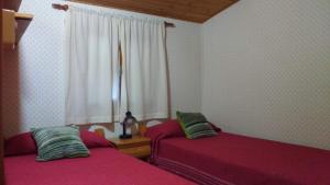 a bedroom with two beds and a window at Cabañas San Valentin in Lago Puelo