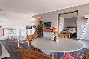 a kitchen and living room with a table and chairs at Waterside on Le Bonheur in Simondium