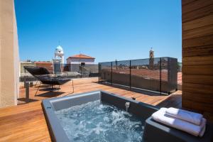 a hot tub on the deck of a balcony at Portou House in Chania Town