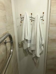 a bathroom with white towels hanging on a wall at Las Palomas in Ventspils