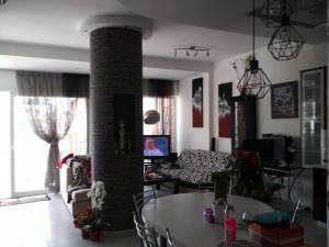una sala de estar con una mesa y un pilar de ladrillo en Blue Maizon en Heraclión