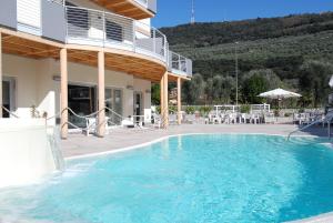 a large swimming pool in front of a house at Primavera ApartmentSuites in Riva del Garda