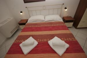 a bedroom with a large bed with two pillows on it at Apartments Irena Krk in Krk