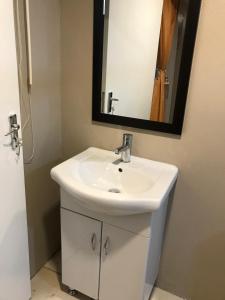 米德蘭的住宿－La Villa Rosa，浴室设有白色水槽和镜子