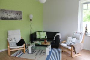 uma sala de estar com um sofá e duas cadeiras em Fewo an der Mühle em Hasselberg