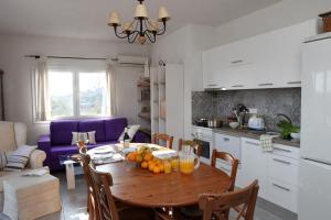 een keuken en eetkamer met een tafel met fruit erop bij Iris 2 in Paralia Katerinis